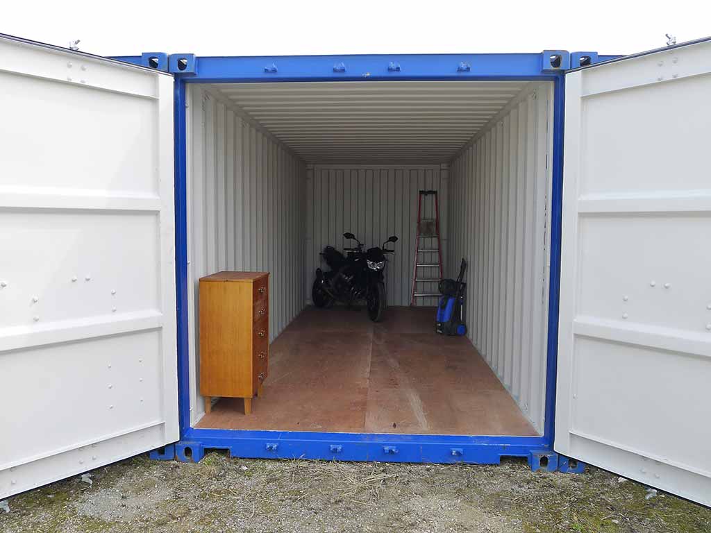 Intérieur d'un box de stockage avec meubles et moto